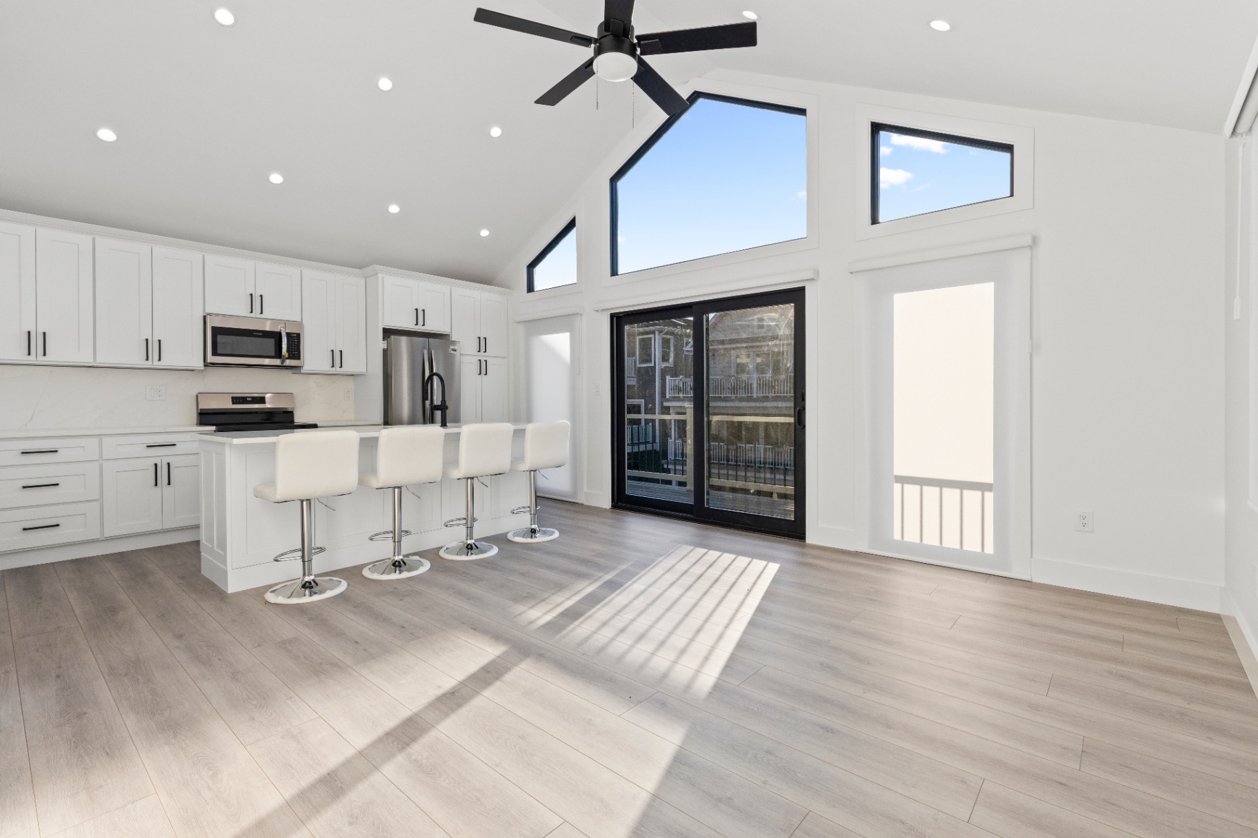 Bright white kitchen with blue island professionally photographed for a coastal listing